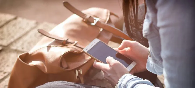 a girl holing a cell phone, contacting movers Star ID
