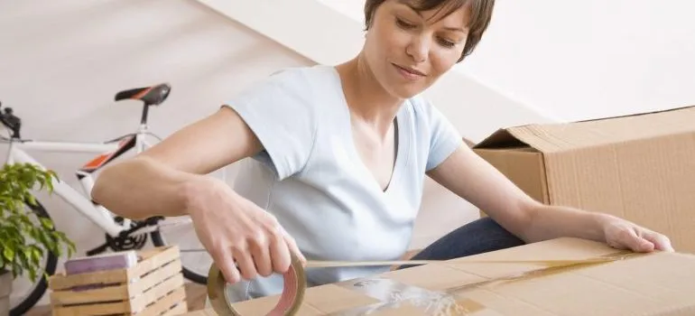 Woman taping moving boxes