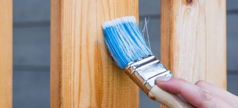 Person painting a fence.