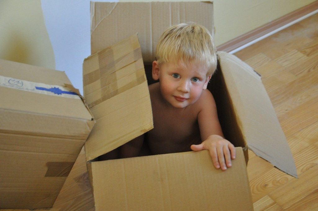 A boy in a cardboard box.