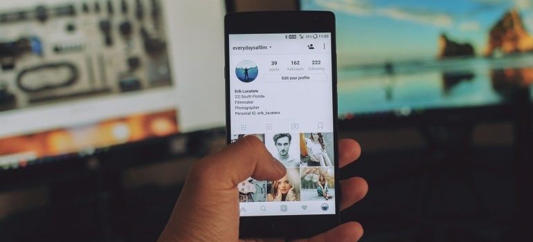 A person holding a phone, looking at Instagram.