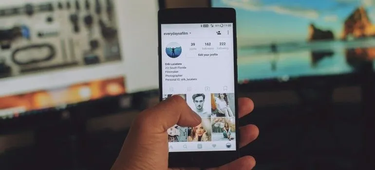 A person holding a phone, looking at Instagram. 