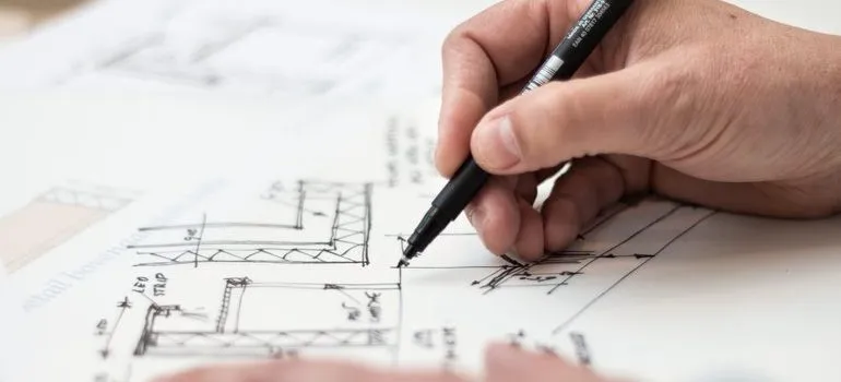 A person using house plans for moving bulky items.