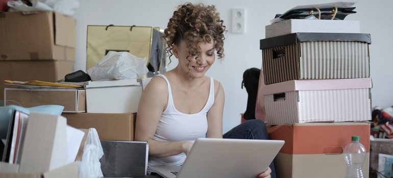 Woman unpacking boxes to settle after moving to Caldwell ID.
