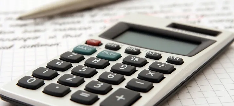 A calculator, pen, and paper