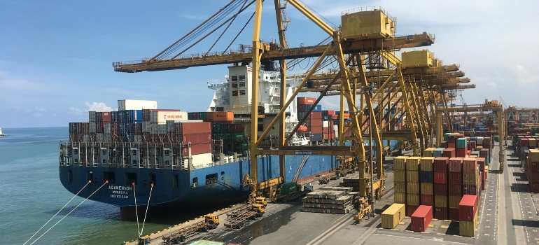 ship on dock near shipping containers