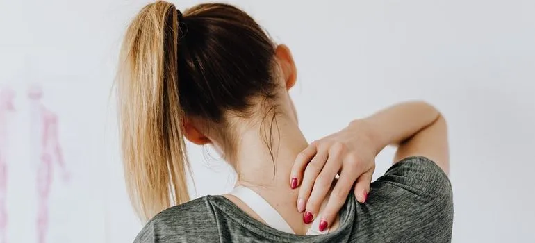Person massaging their neck to avoid moving day injuries.