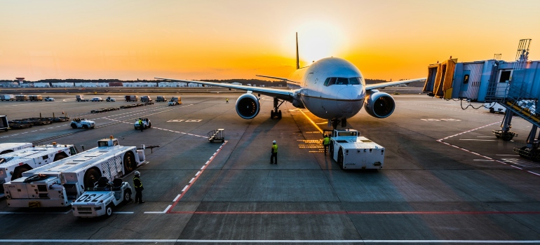 A gray airplane on an airport at sunset