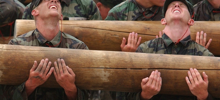 Group of soldiers lifting heavy logs