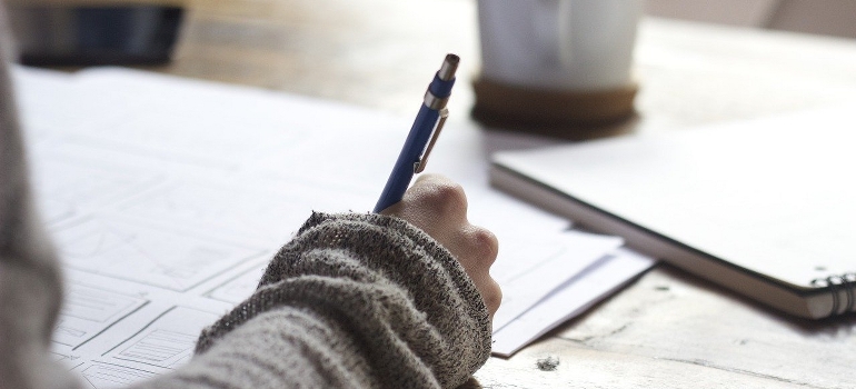 A hand writing a list