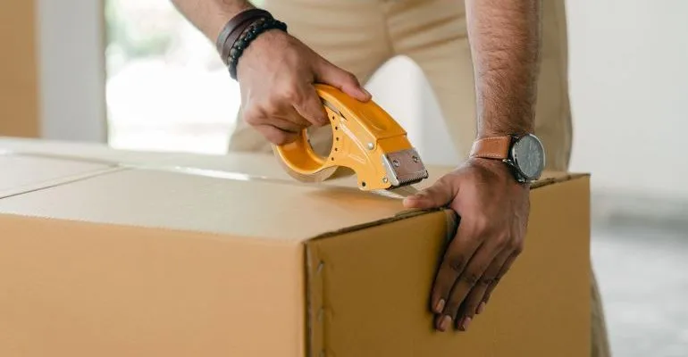 Person packing a box for storage