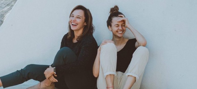 two female friends, sitting, laughing