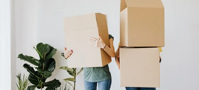 Two people holding boxes.