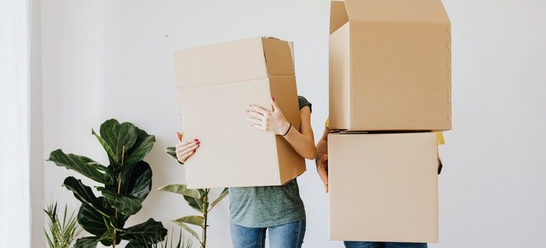 Couple holding boxes.