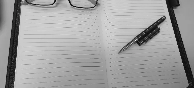 an empty notebook with a pen and glasses 