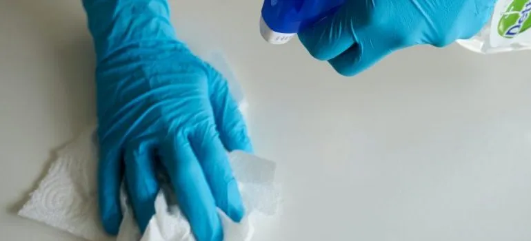 person-wearing-blue-gloves-cleaning