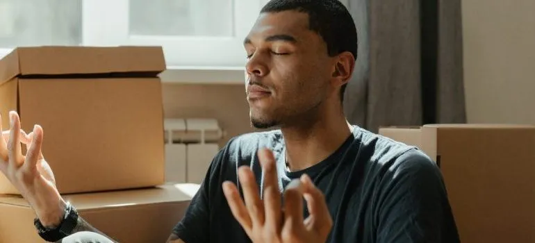 man-sitting-moving-boxes-around-him