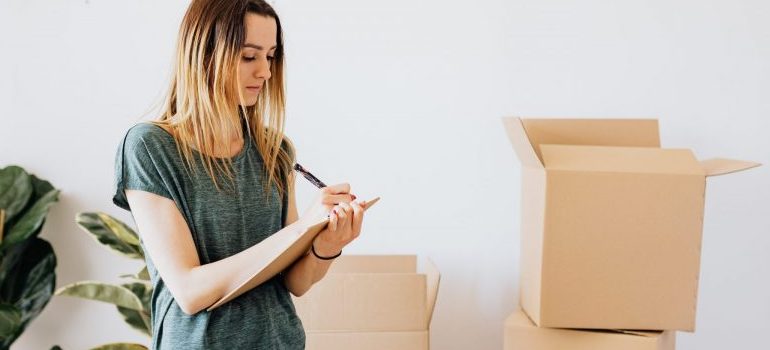 woman-writing-moving-boxes-behind