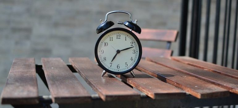 An alarm clock on a table to look at in order to save time while packing for moving.