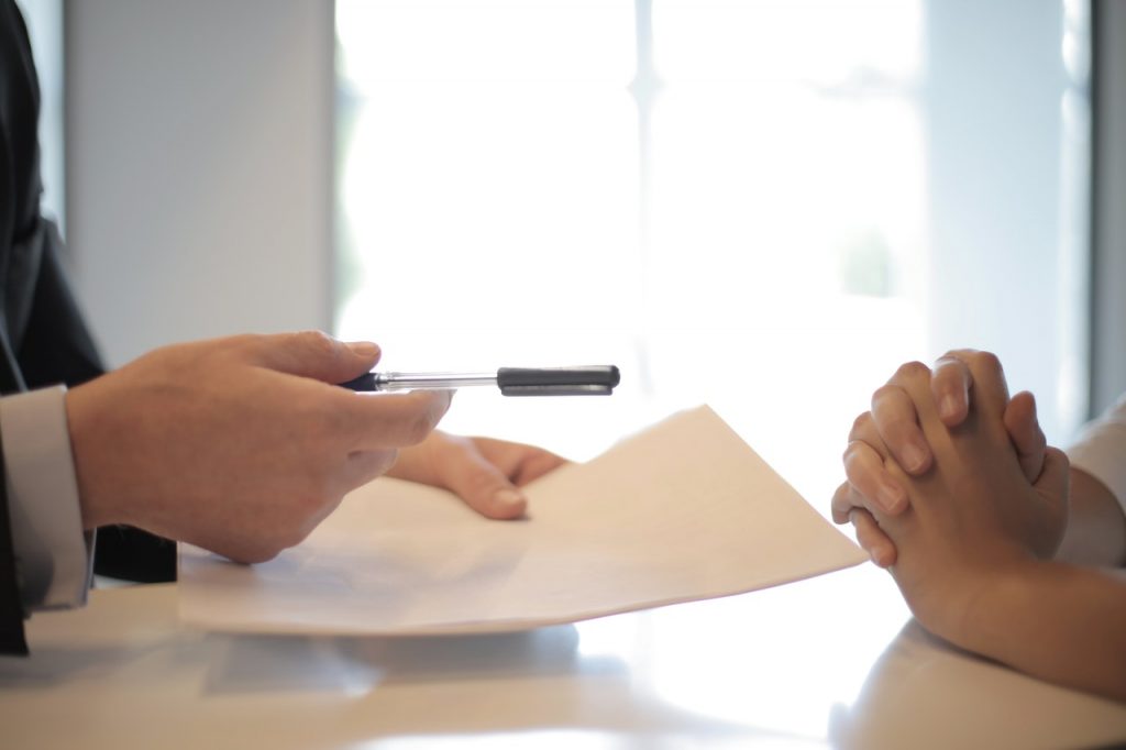Person holding a pen and a piece of paper