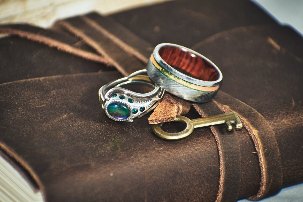 Silver rings and a key on a brown leather book cover