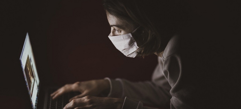 A woman wearing a mask trying to find reliable movers during the pandemic