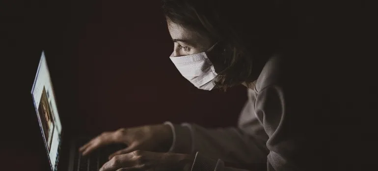 A woman wearing a mask trying to find reliable movers during the pandemic