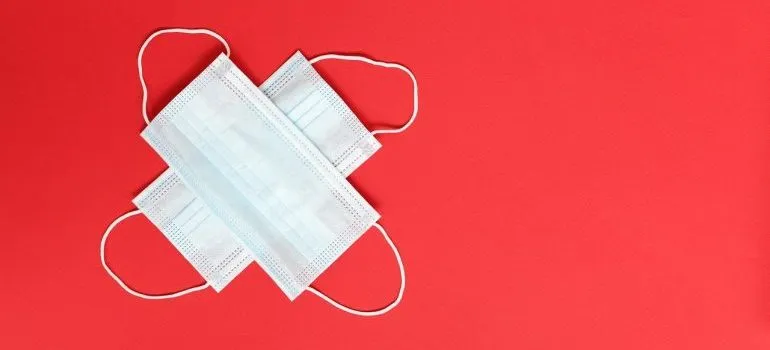 Two surgical masks on a red surface. 