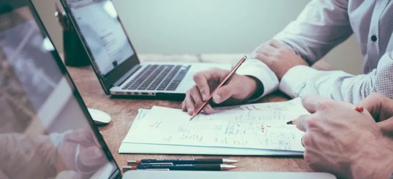 Two persons planning a move during a crisis in a notebook. 