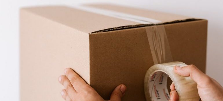 Person packing a box for moving during Coronavirus pandemic