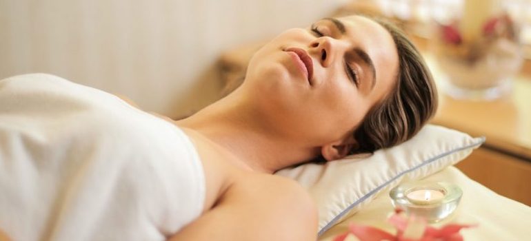 woman laying down with eyes closed, spa