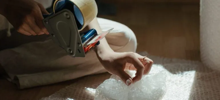person using bubble wrap, packing