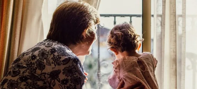 older woman with a baby near window