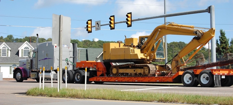 truck carrying a large digger