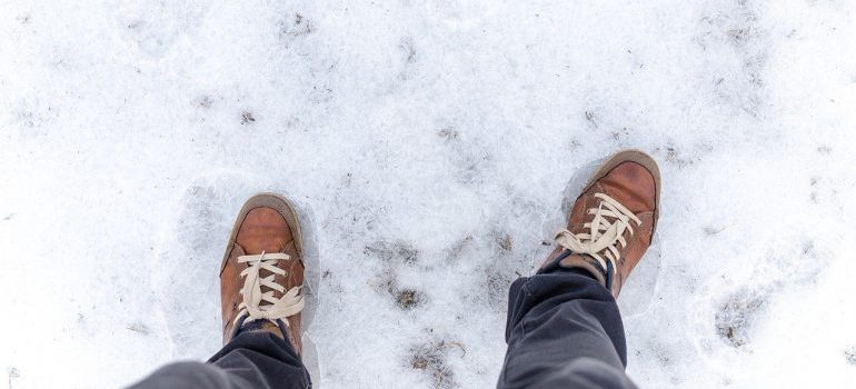 A man standing on ice in winter boots.