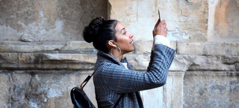 A woman holding a phone and taking a photo.