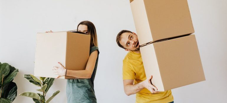 Couple carrying moving boxes