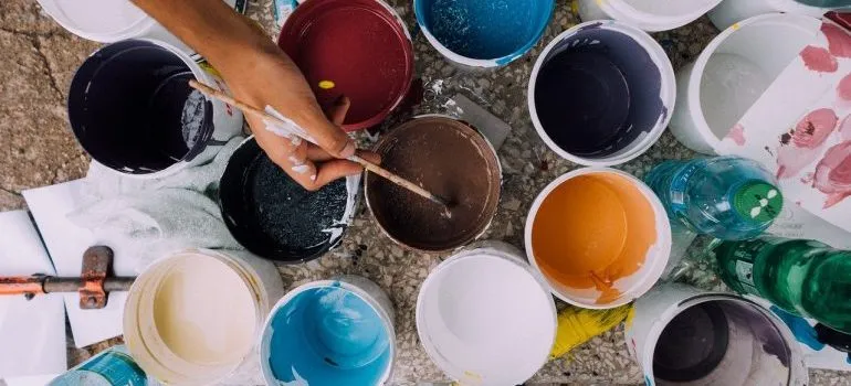 A person working with cans of paint.