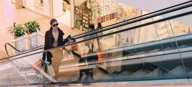 A woman in a mall with shopping bags, experiencing benefits of living in Kuna ID.