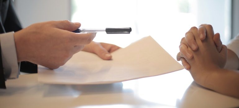 Person signing a contract after following tips for selling your Boise home.