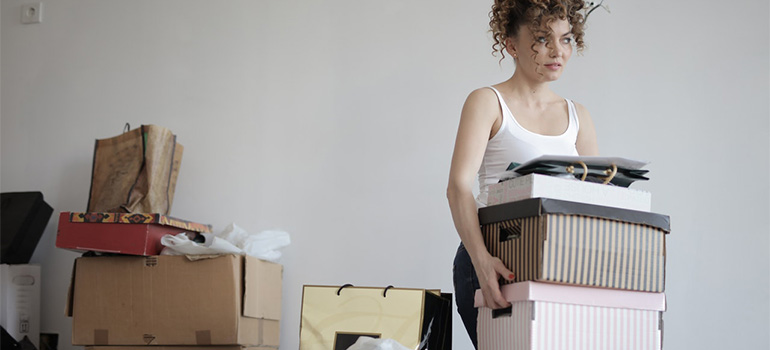 A woman carrying boxes, sharing your wish to repurpose your at-home storage spaces