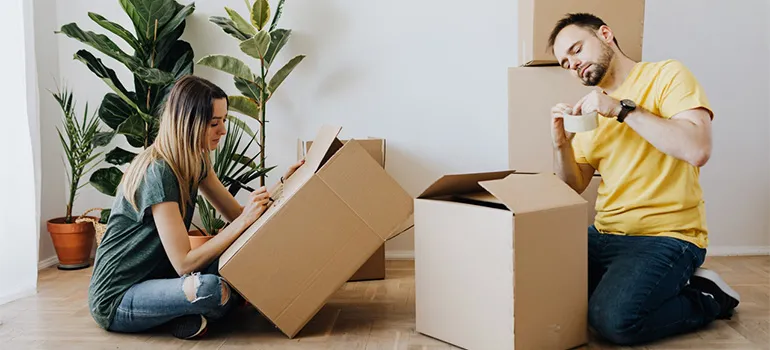 A girl and a guy packing boxes
