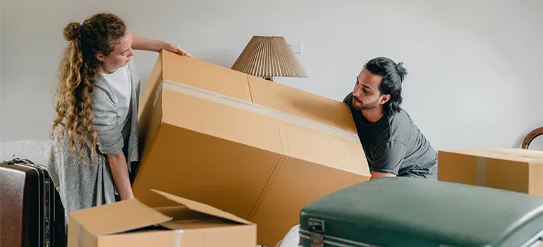 Two people carrying a box