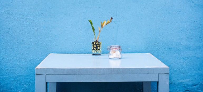 A blue table in front of a blue wall.
