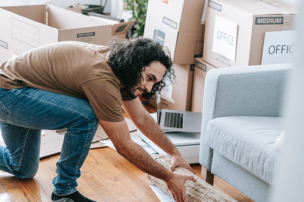 A man packing a carpet for moving