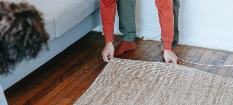 A couple preparing rugs and carpets for moving.