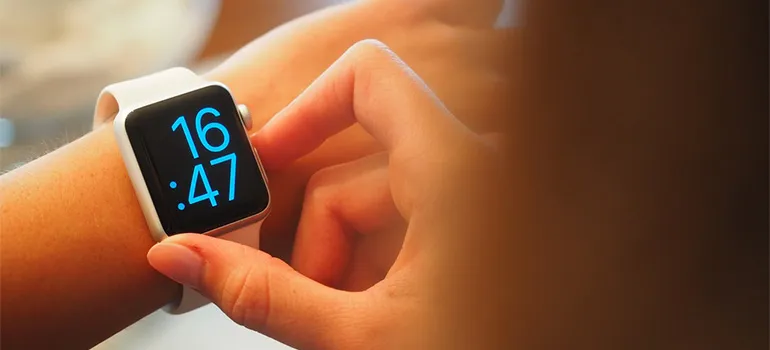 A woman looking at her digital watch