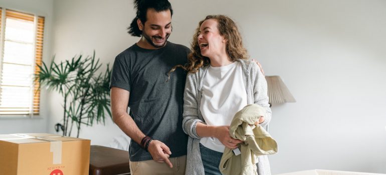 Couple smiling while unpacking boxes