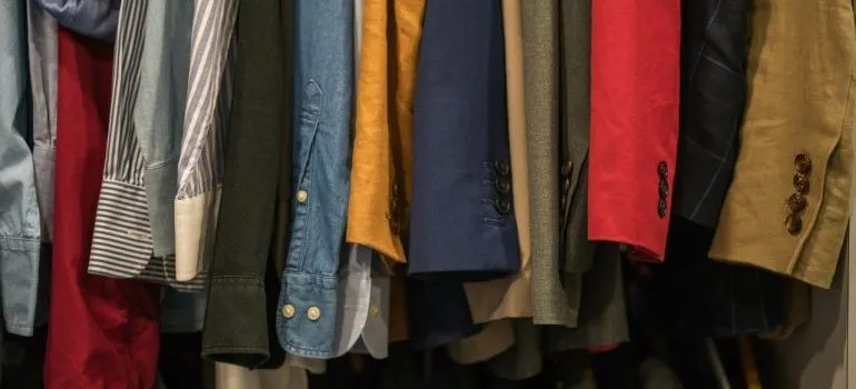 Shirts of different colors in a closet.