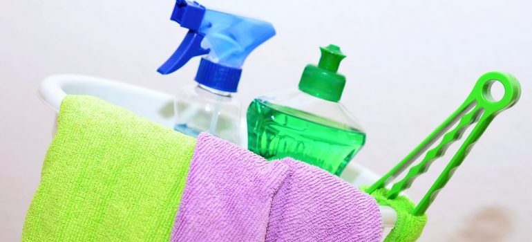 A bucket full of cleaning supplies to use before moving your fridge.